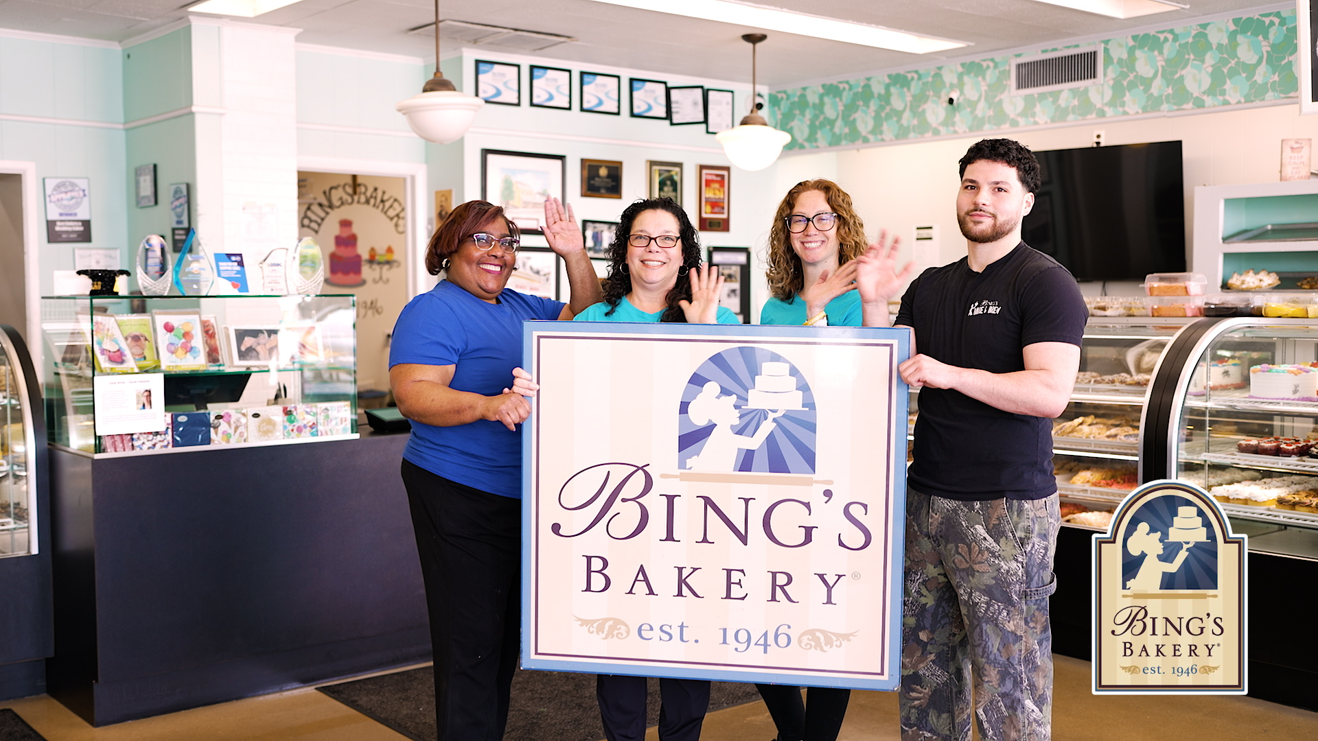 The Bings Bakery team holding their est. 1946 sign inside the shop